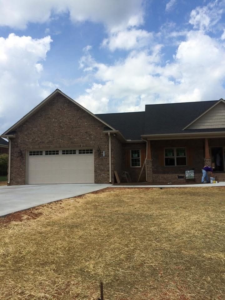 Almond short-panel garage door on a new construction brick ranch home