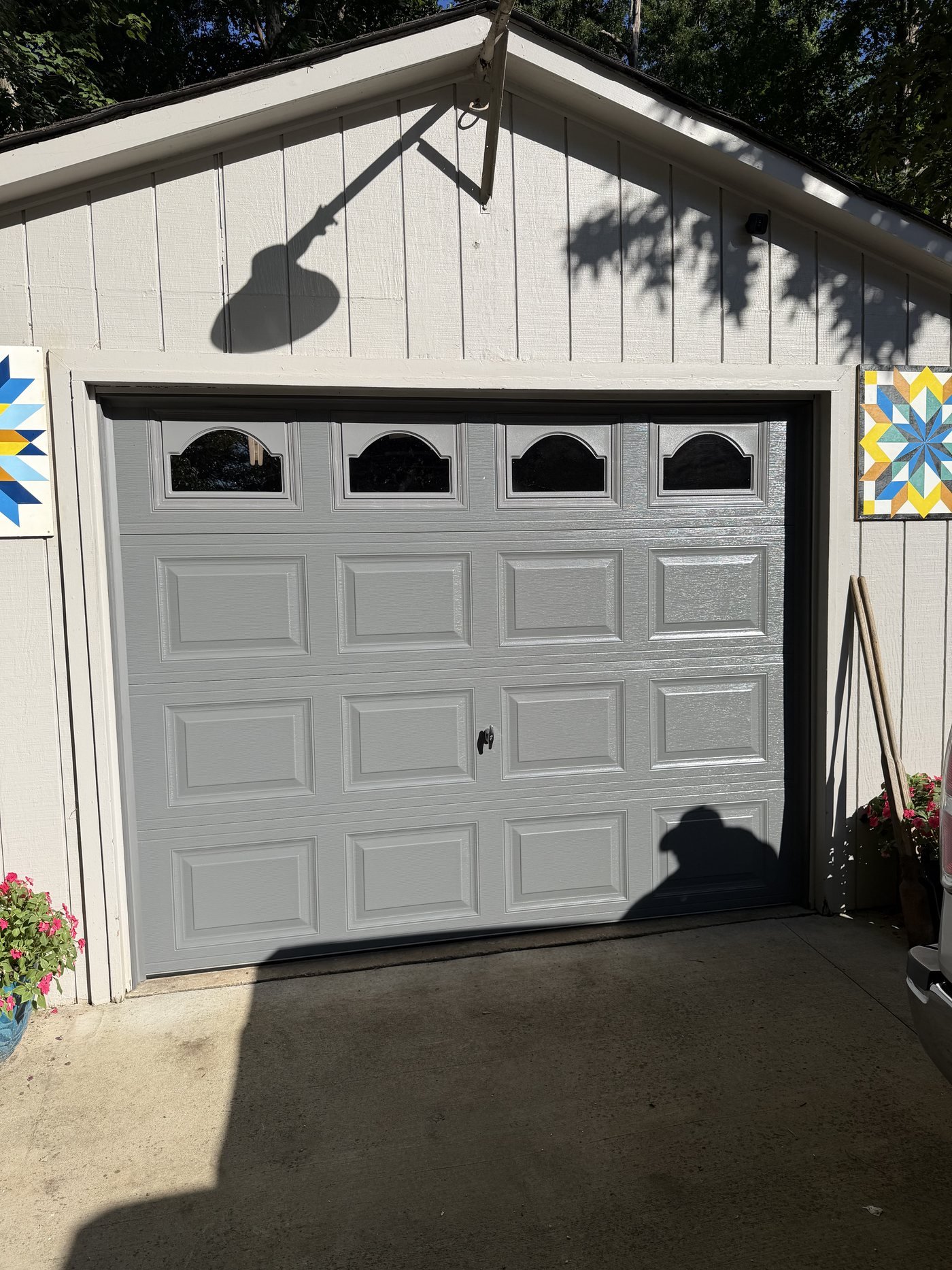 White short-panel garage door with arched glass windows on a detached garage