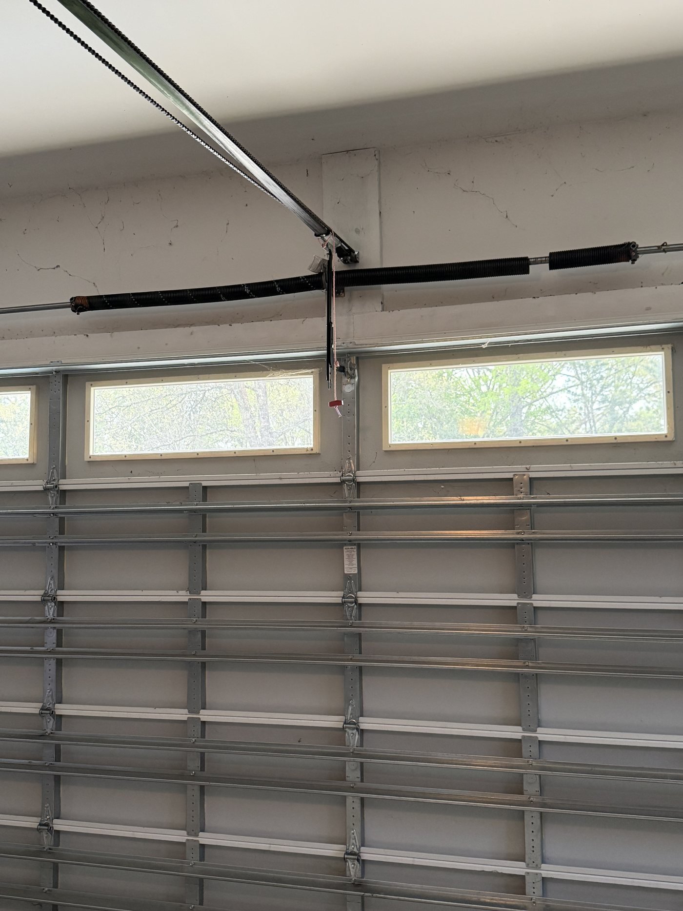 Torsion springs, opener rail and track above an insulated garage door